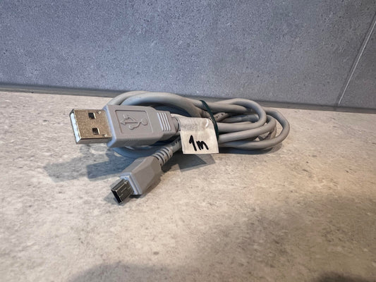 Coiled USB A to USB Mini-B cable on a light surface