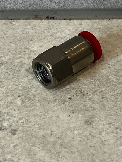 Coaxial cable compression connector with red compression ring lying on floor