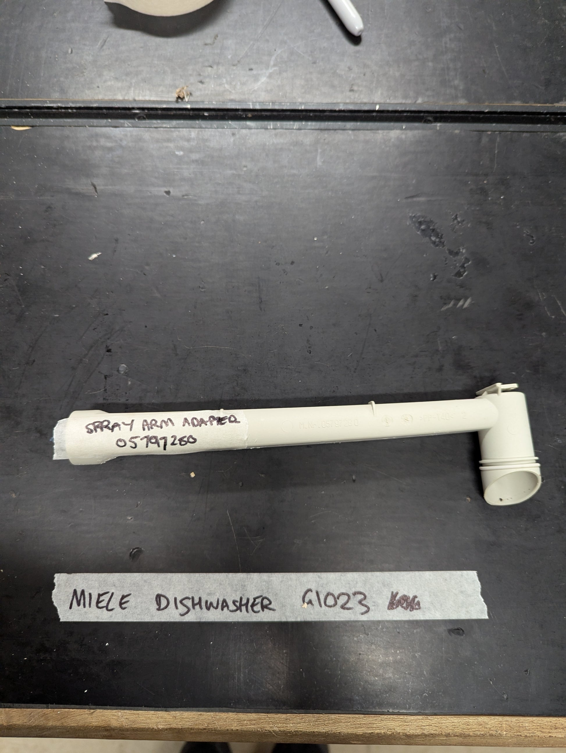 Miele G1023 dishwasher spray arm adapter on black surface