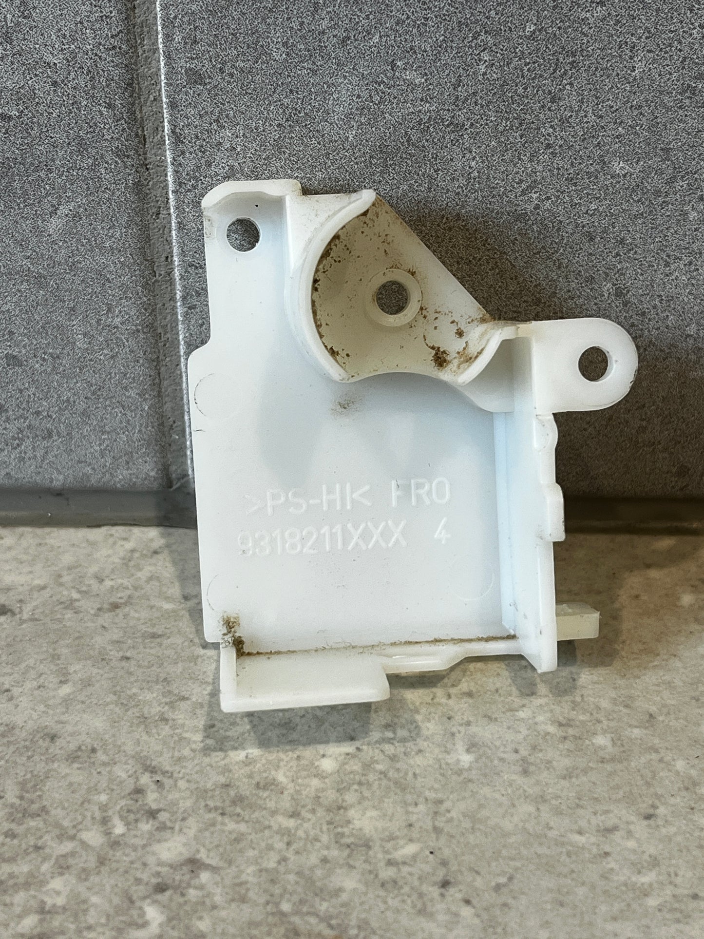 White plastic mounting bracket component with screw holes