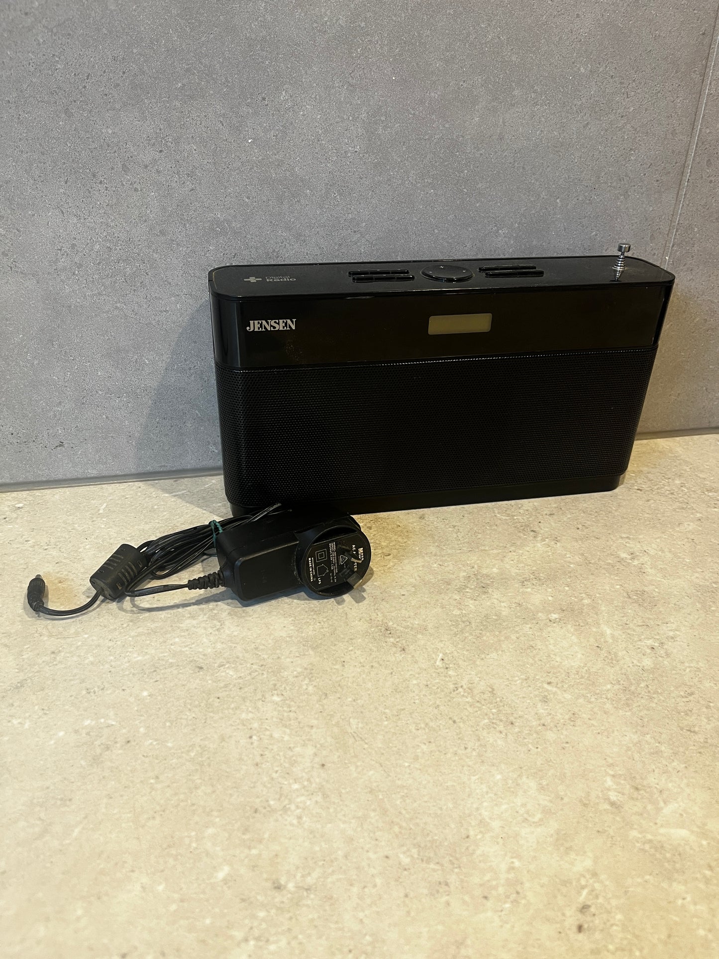 Jensen digital AM/FM radio with AC adapter on countertop