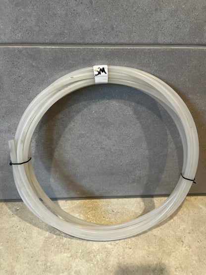 Coiled clear silicone tubing with 5M label on tiled floor background