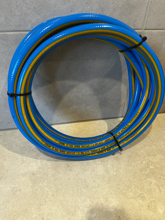 Coiled blue and yellow garden water hose tied with black straps on floor