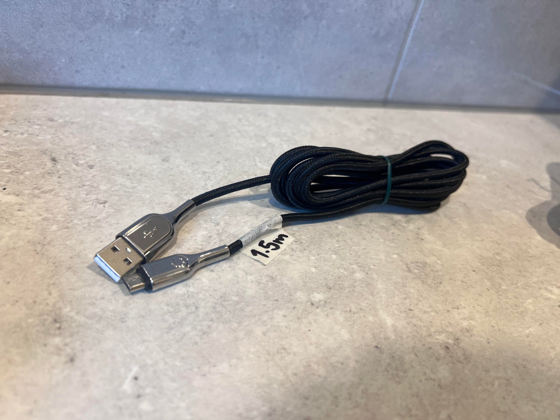 Braided 1.5 meter USB-A to USB-C charging cable on a stone surface