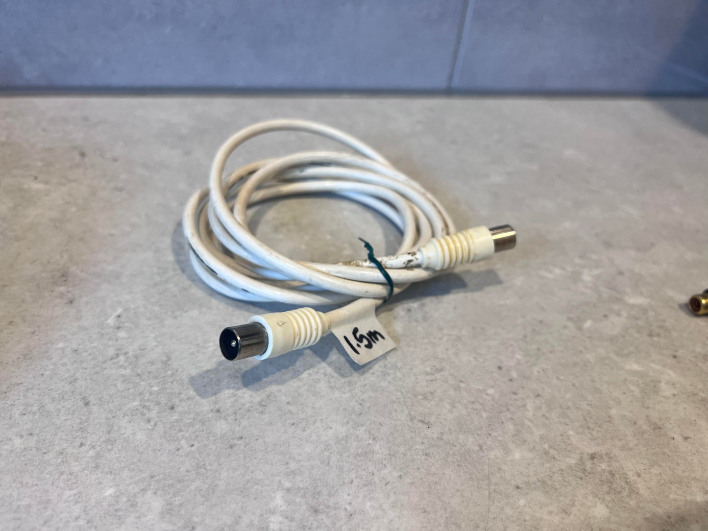 1.5m male-to-female white coaxial cable coiled on a gray surface