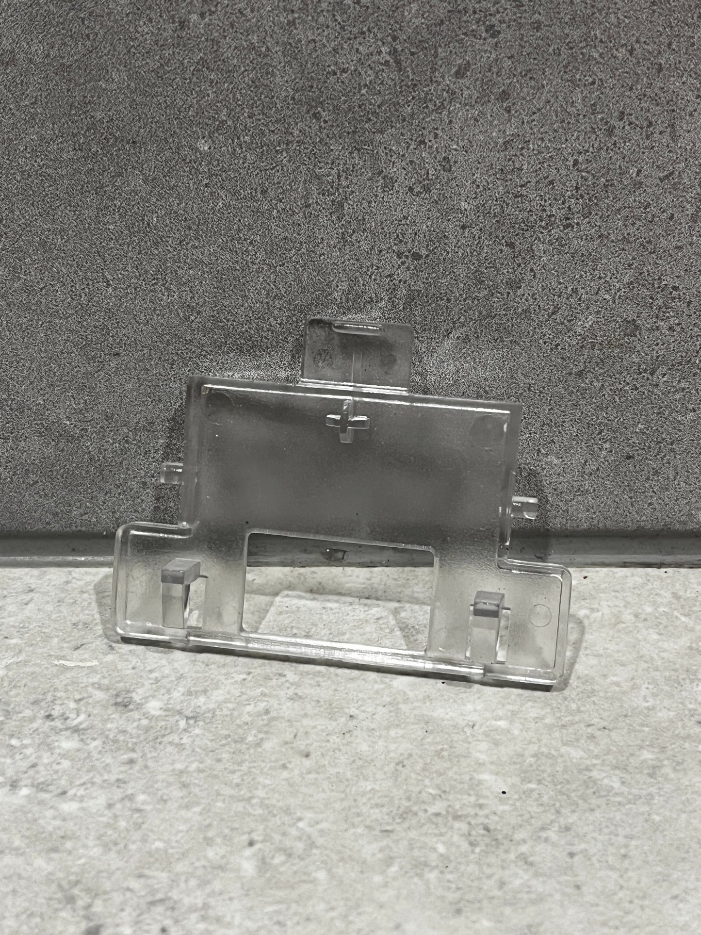 Clear plastic mounting bracket with clips and slots for secure attachment