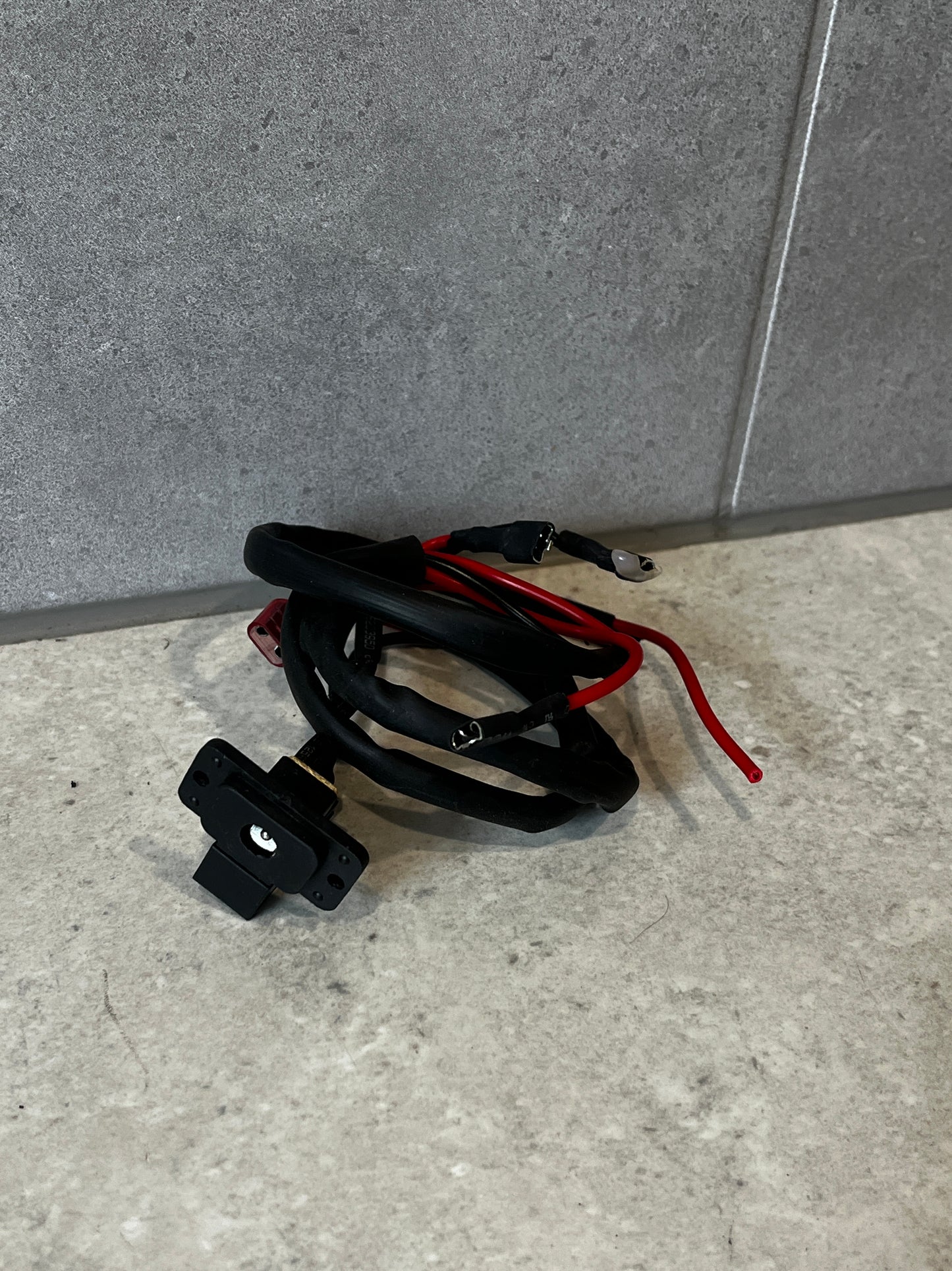 Universal power outlet socket with attached wiring harness on gray surface