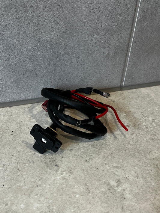 Universal power outlet socket with attached wiring harness on gray surface