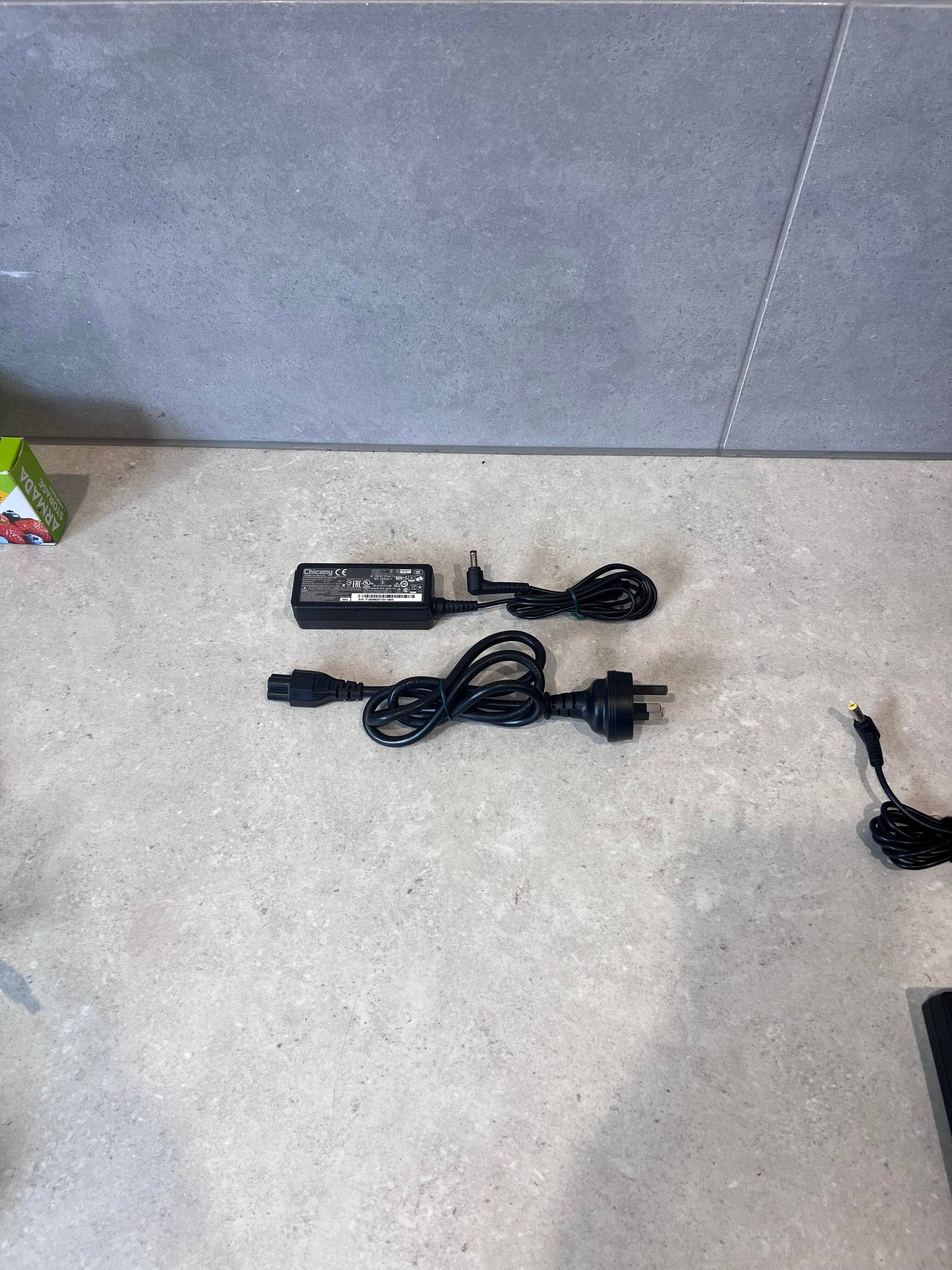 Chicony laptop power adapter and cable set on a countertop