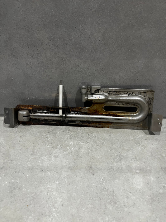 Metal oven burner assembly with attached ceramic ignition electrode and mounting brackets