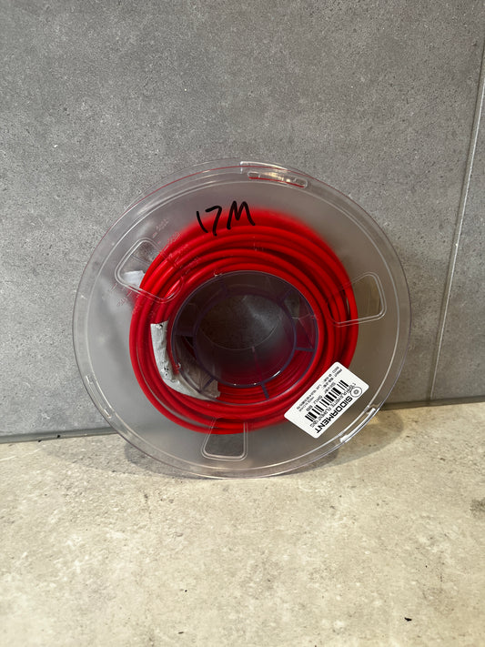Top view of red polyethylene tubing on a clear plastic spool