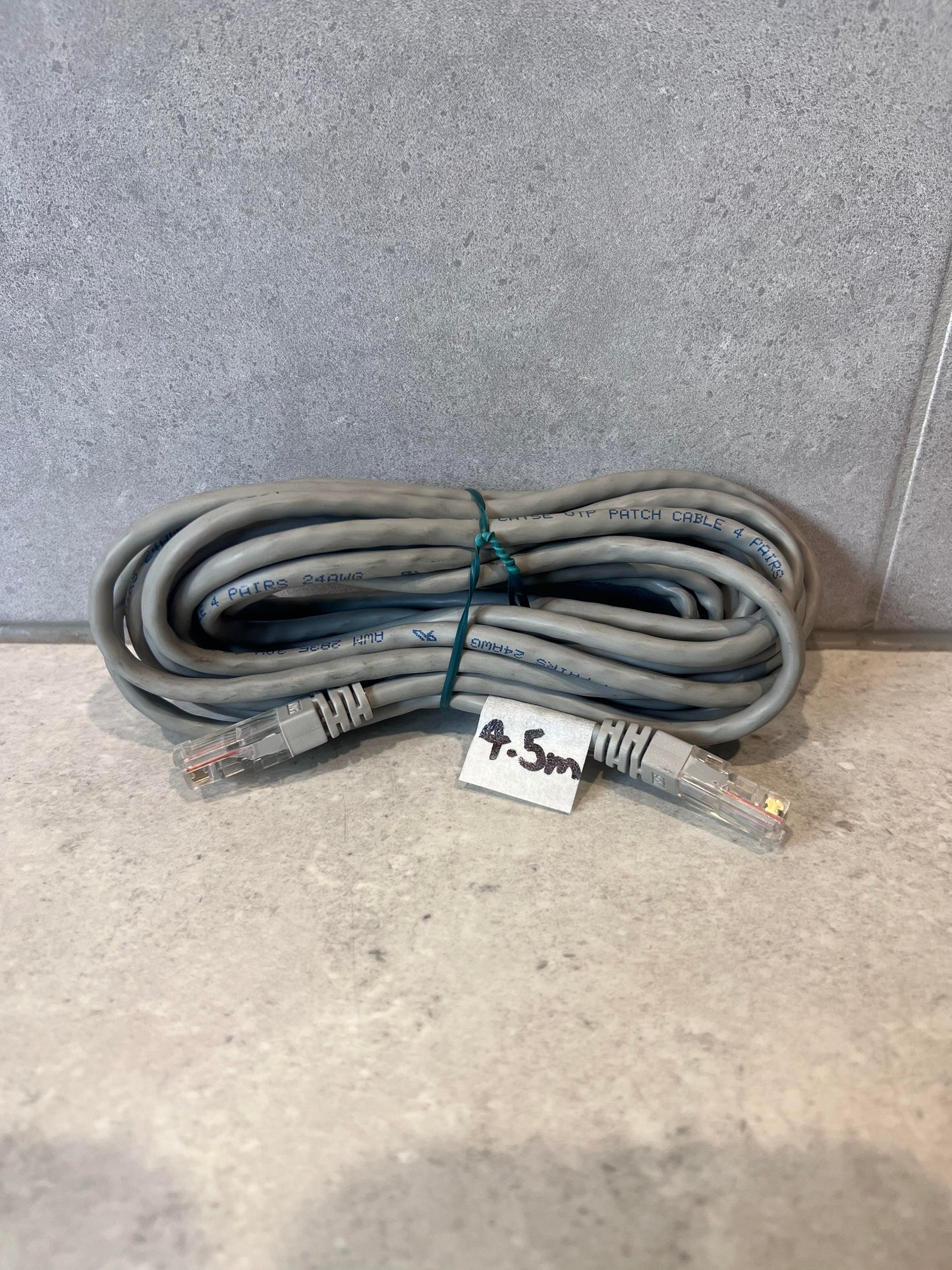 4.5 meter gray Ethernet patch cable with RJ45 connectors coiled on a countertop