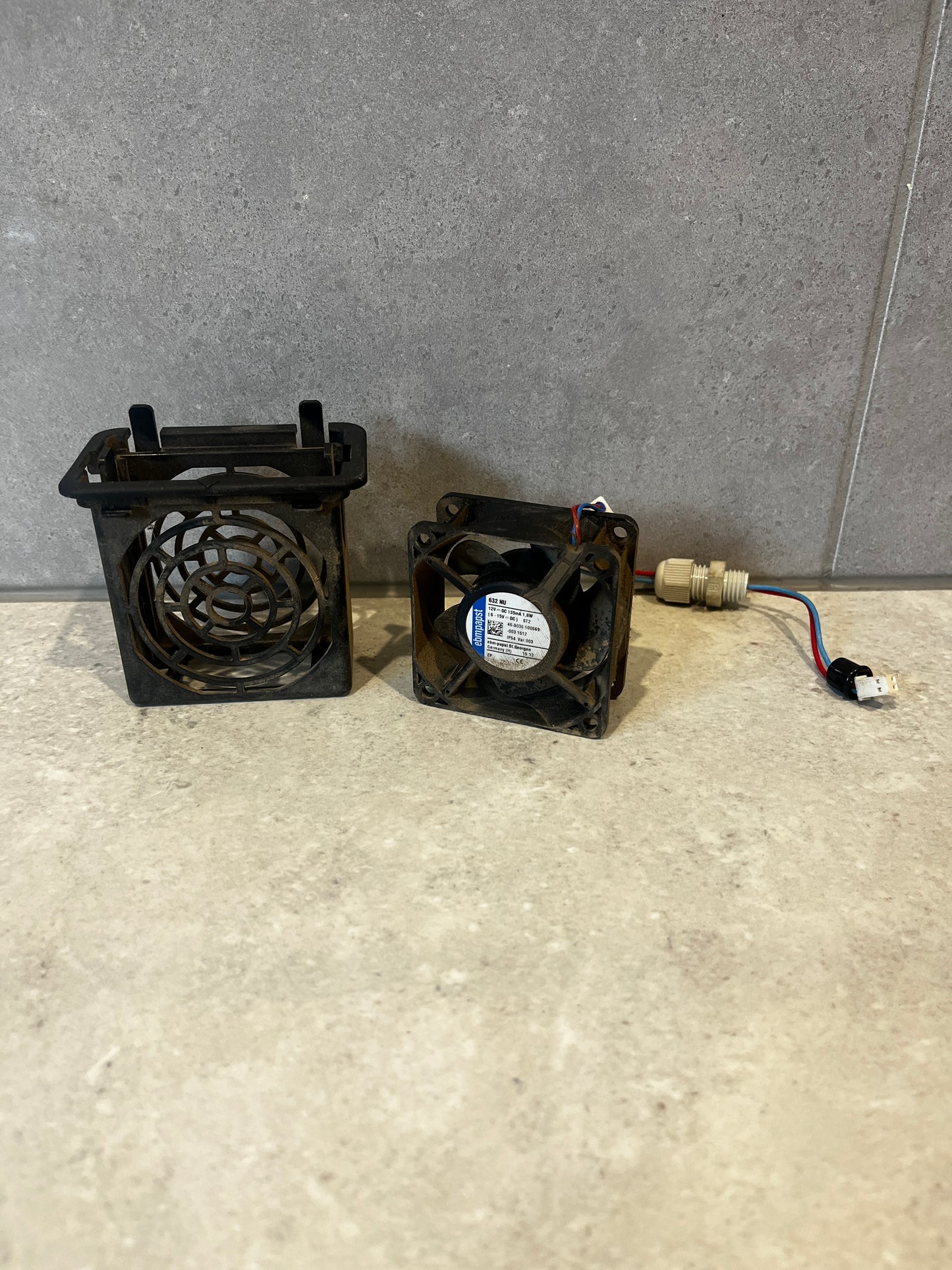 ebm-papst 632 NU 12V DC axial fan with protective housing and wiring on a stone surface