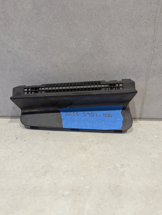 Black plastic vent grille component on a light surface