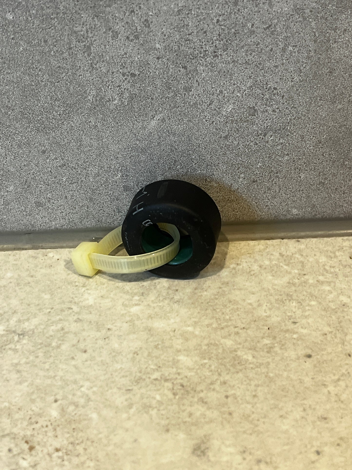 Rubber grommet with nylon cable tie on stone surface