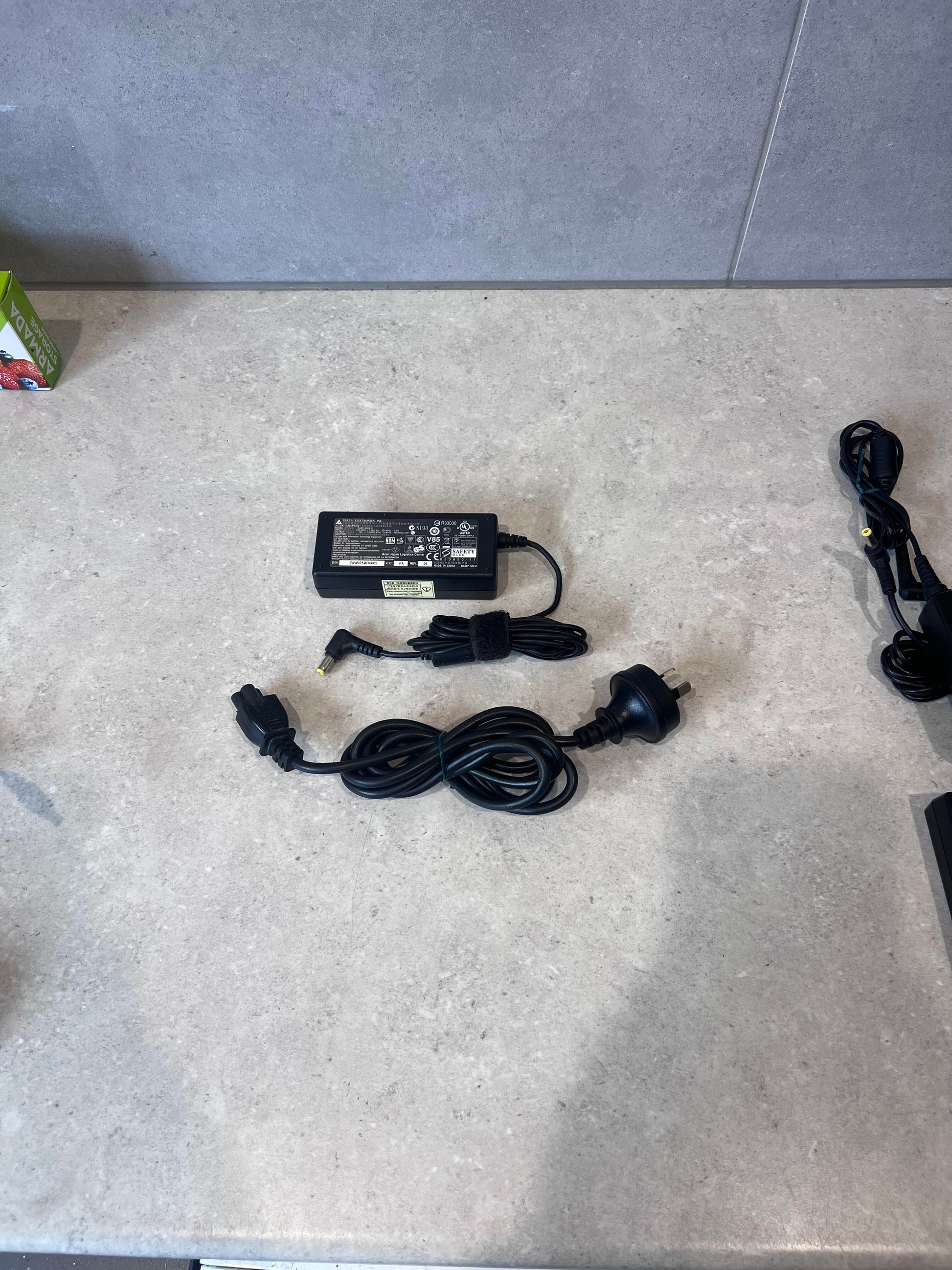 Delta Electronics AC/DC adapter with power cable on countertop