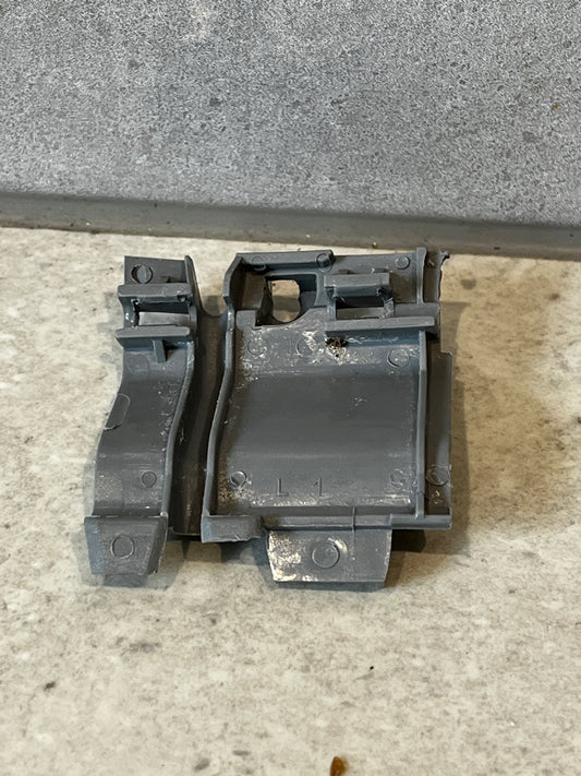 Gray plastic mechanical clip set on a light surface, front view