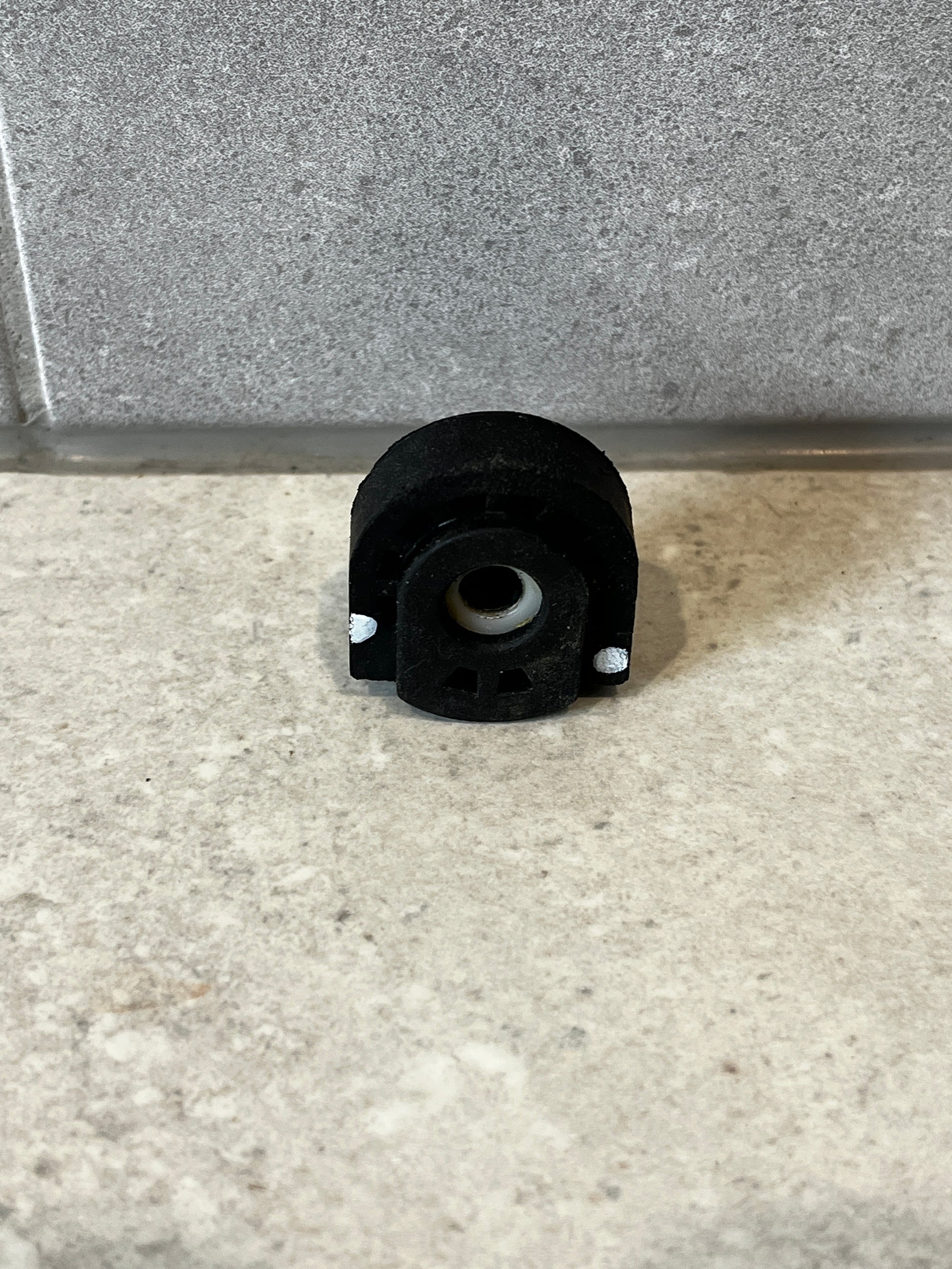 Heavy-duty rubber bushing mount with metal sleeve on stone surface