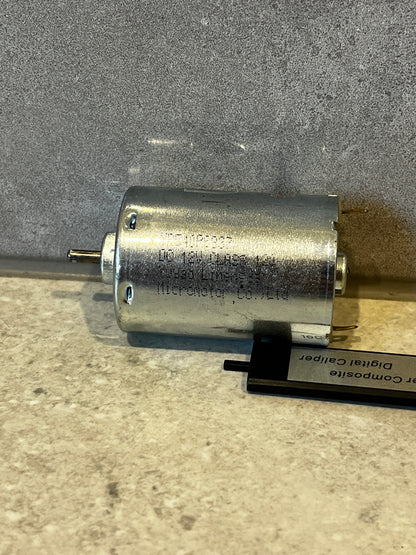 Side view of a small cylindrical electric DC motor with metal housing and output shaft