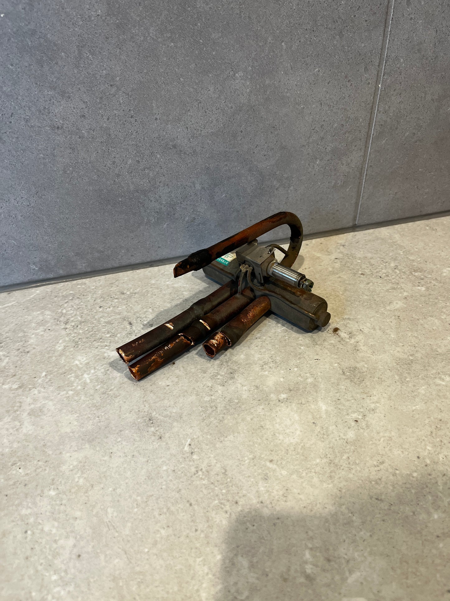 Copper refrigeration solenoid valve with multiple copper tubing connections on a light surface