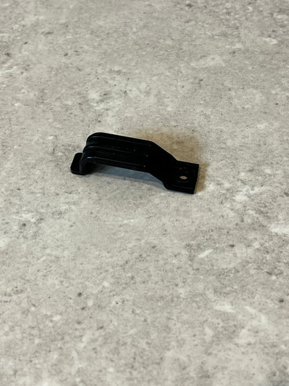 Black plastic mounting bracket clip on gray surface