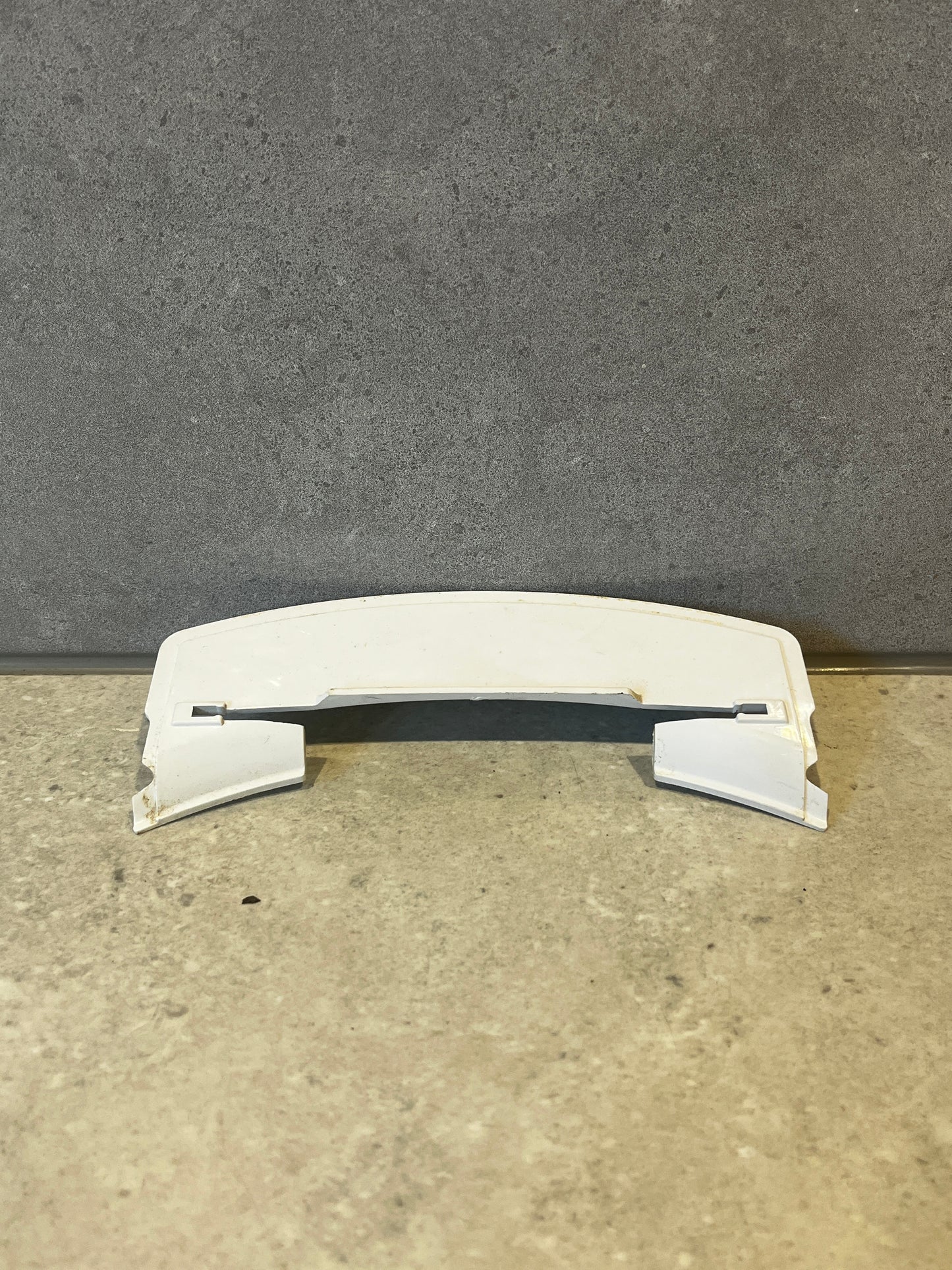 White curved ABS plastic appliance cover on a stone surface