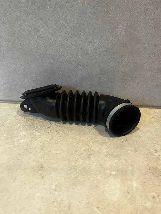 Flexible black EPDM automotive air intake hose on a neutral surface