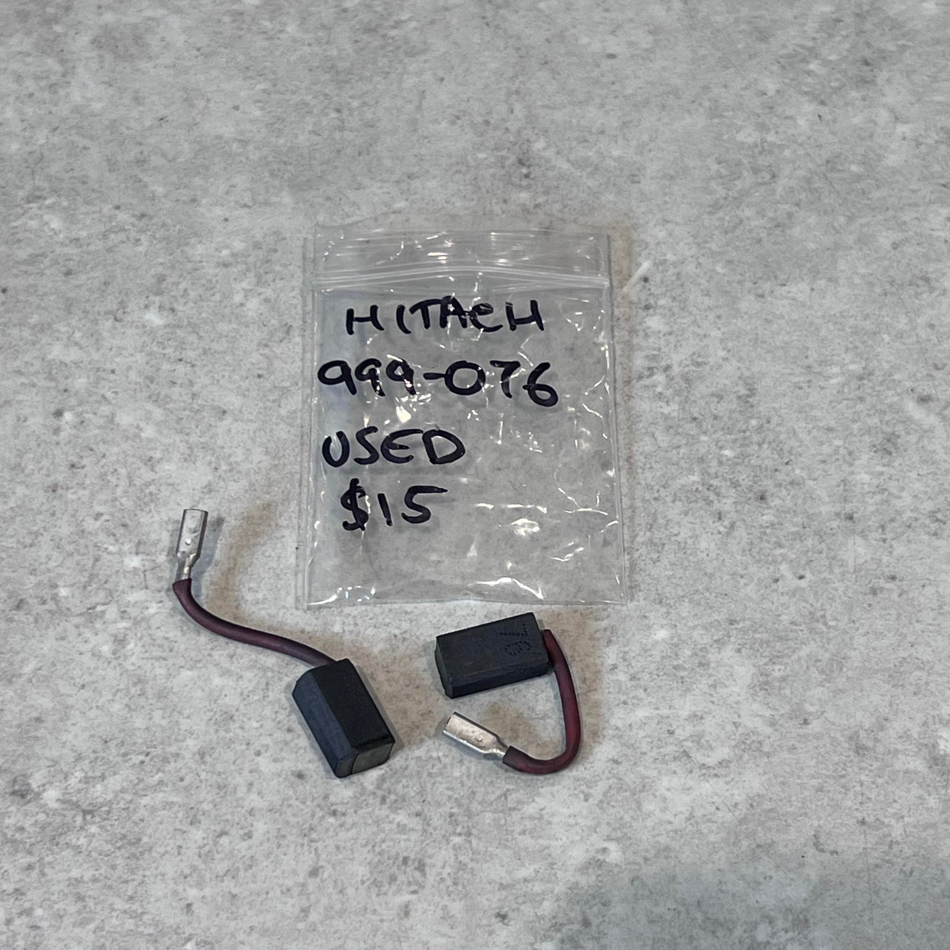 Used Hitachi 999-076 carbon brush pair with wire leads and labeled plastic bag