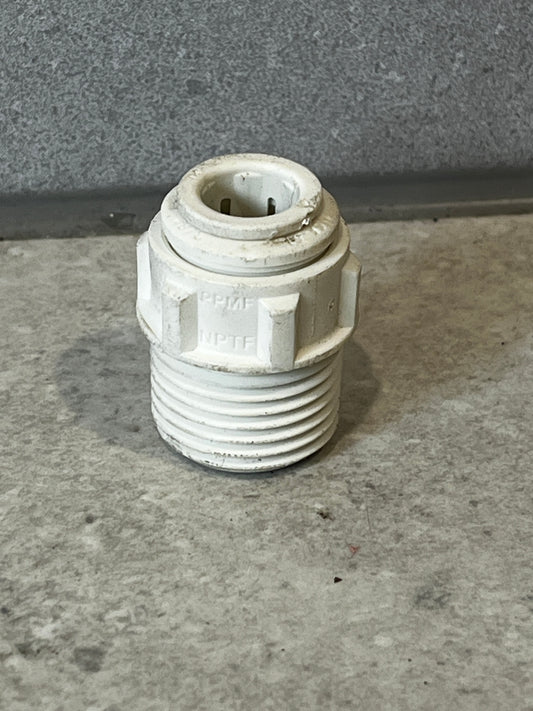 Threaded plastic pipe connector fitting on concrete surface