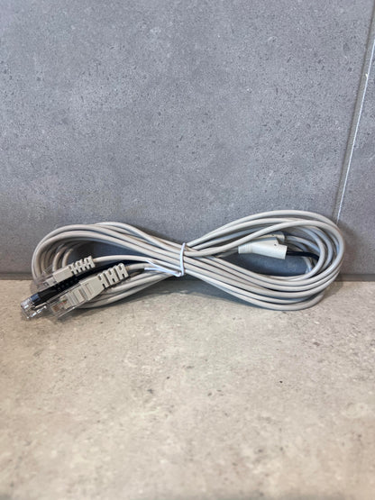 Coiled Ethernet patch cable with dual connectors on a gray surface