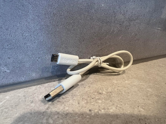 Logitech USB A to Mini-B cable coiled on a granite surface