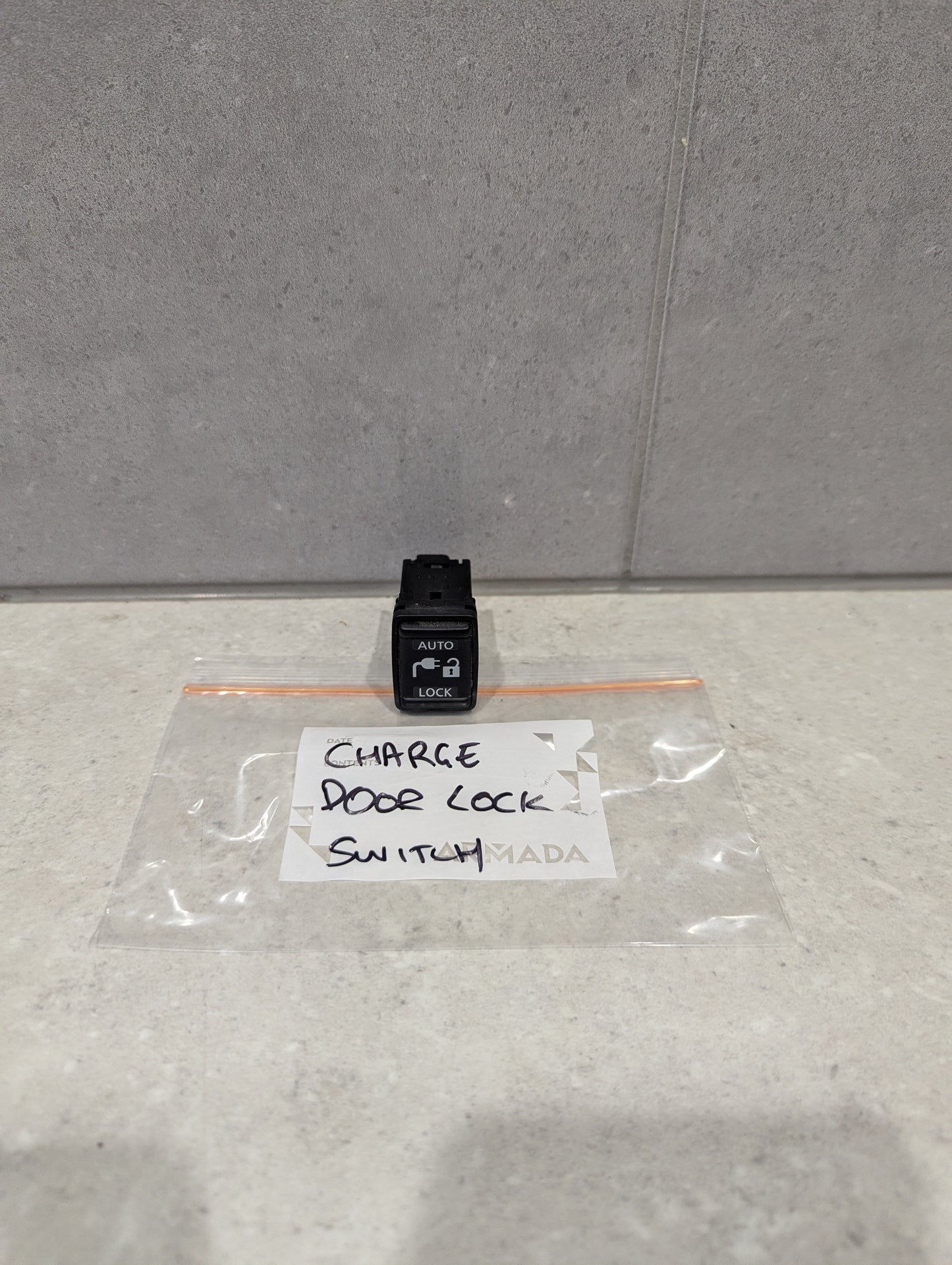 Auto door lock switch on countertop with labeled plastic bag