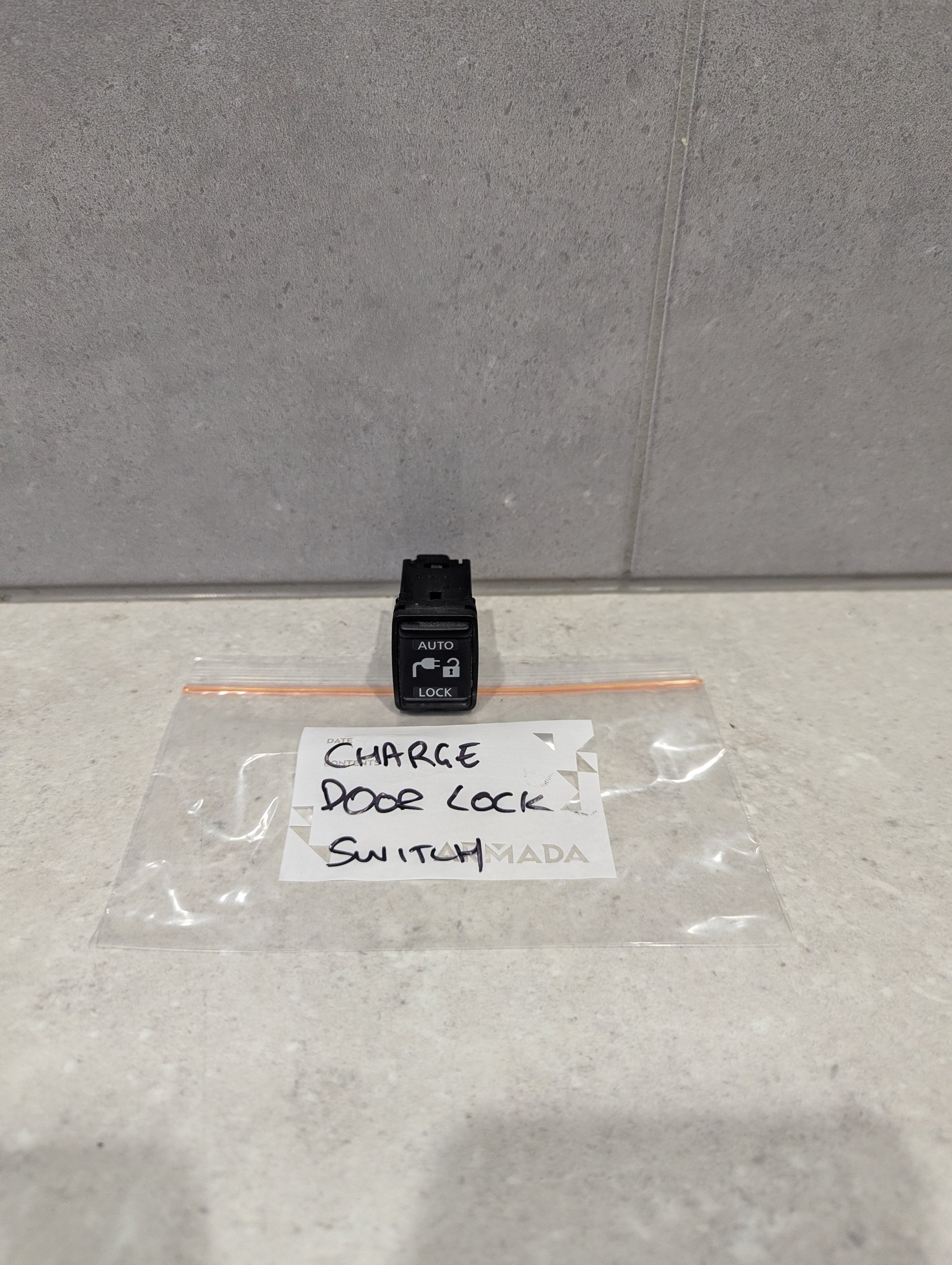 Auto door lock switch on countertop with labeled plastic bag