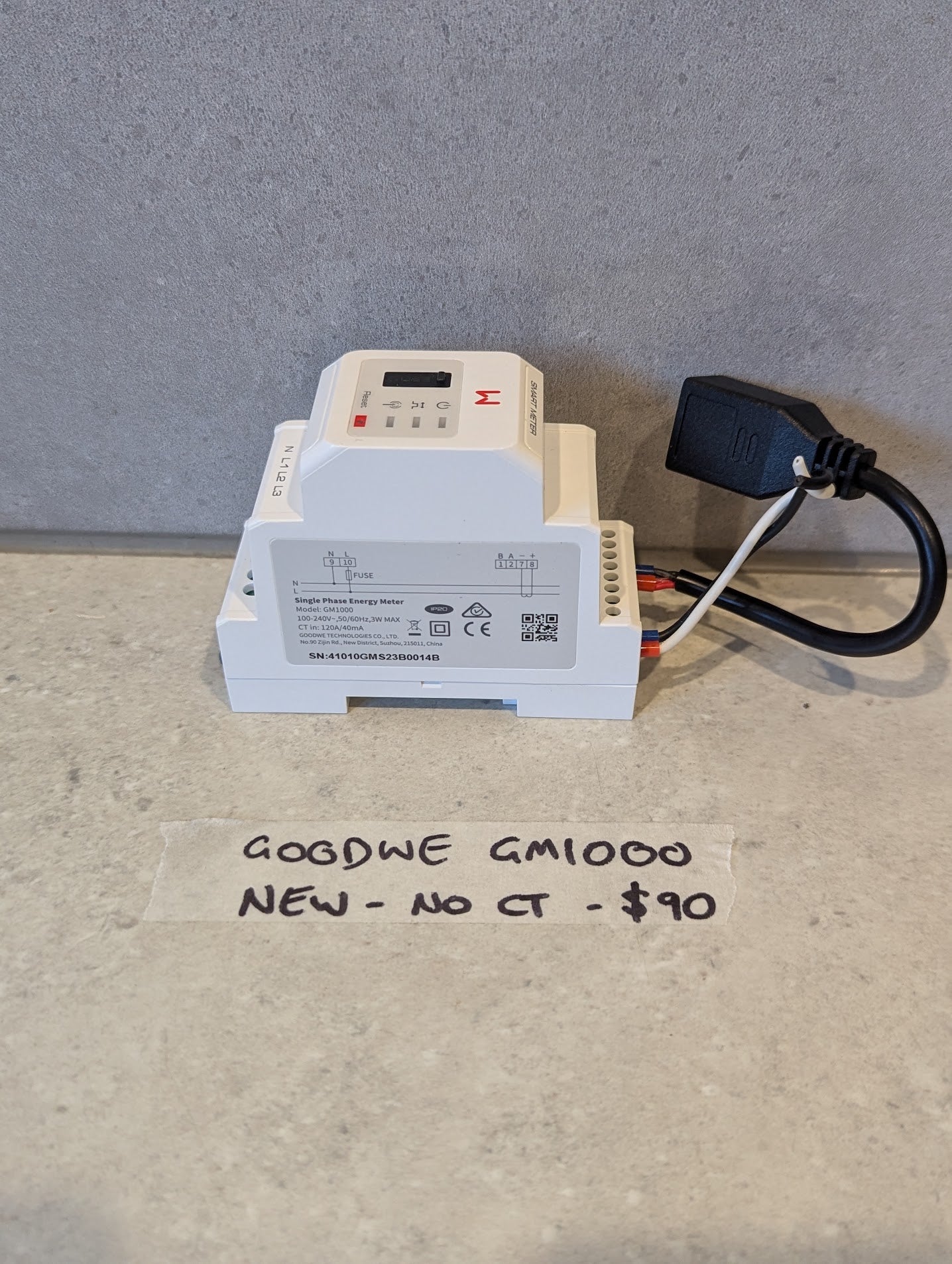 GOGDWE GM1000 single phase energy meter on tabletop with wires and price note
