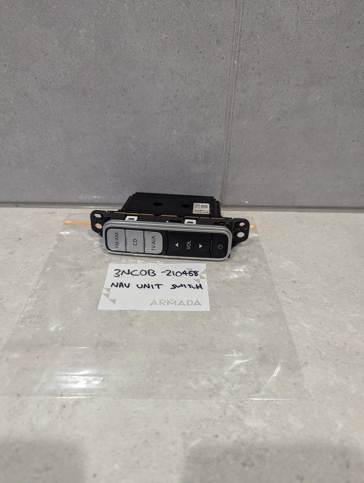 Nissan Armada navigation unit switch with labeled audio control buttons placed on a countertop