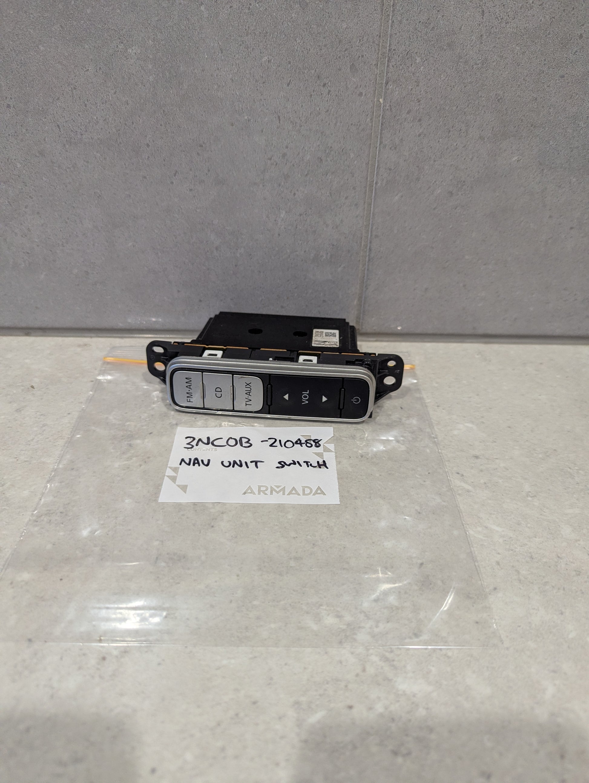 Nissan Armada navigation unit switch with labeled audio control buttons placed on a countertop