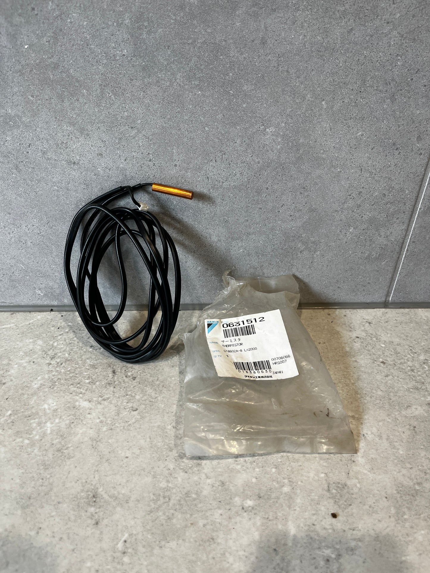 Daikin temperature sensor probe with black cable and packaging.