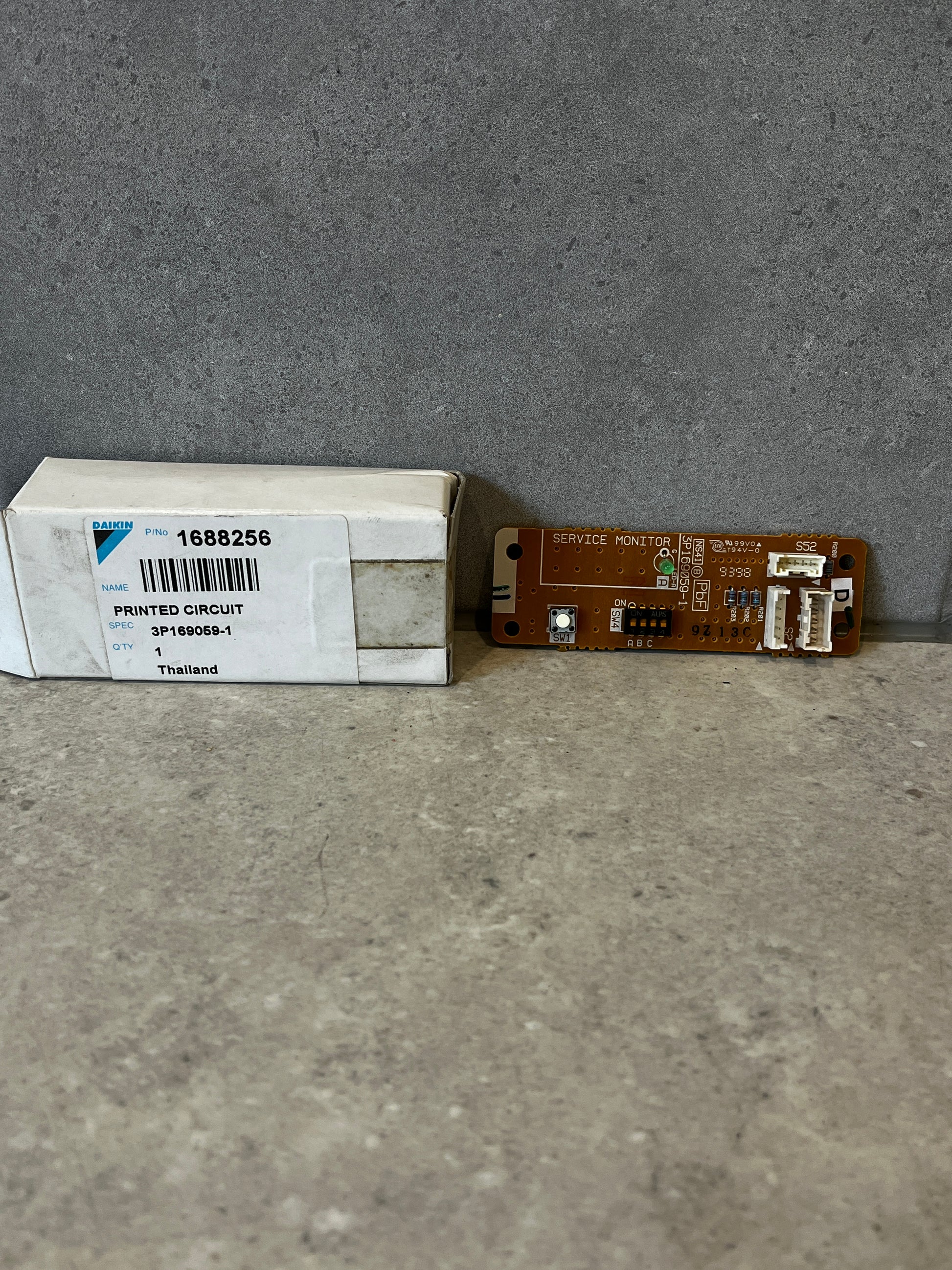 Daikin printed circuit board with labeled box on gray surface