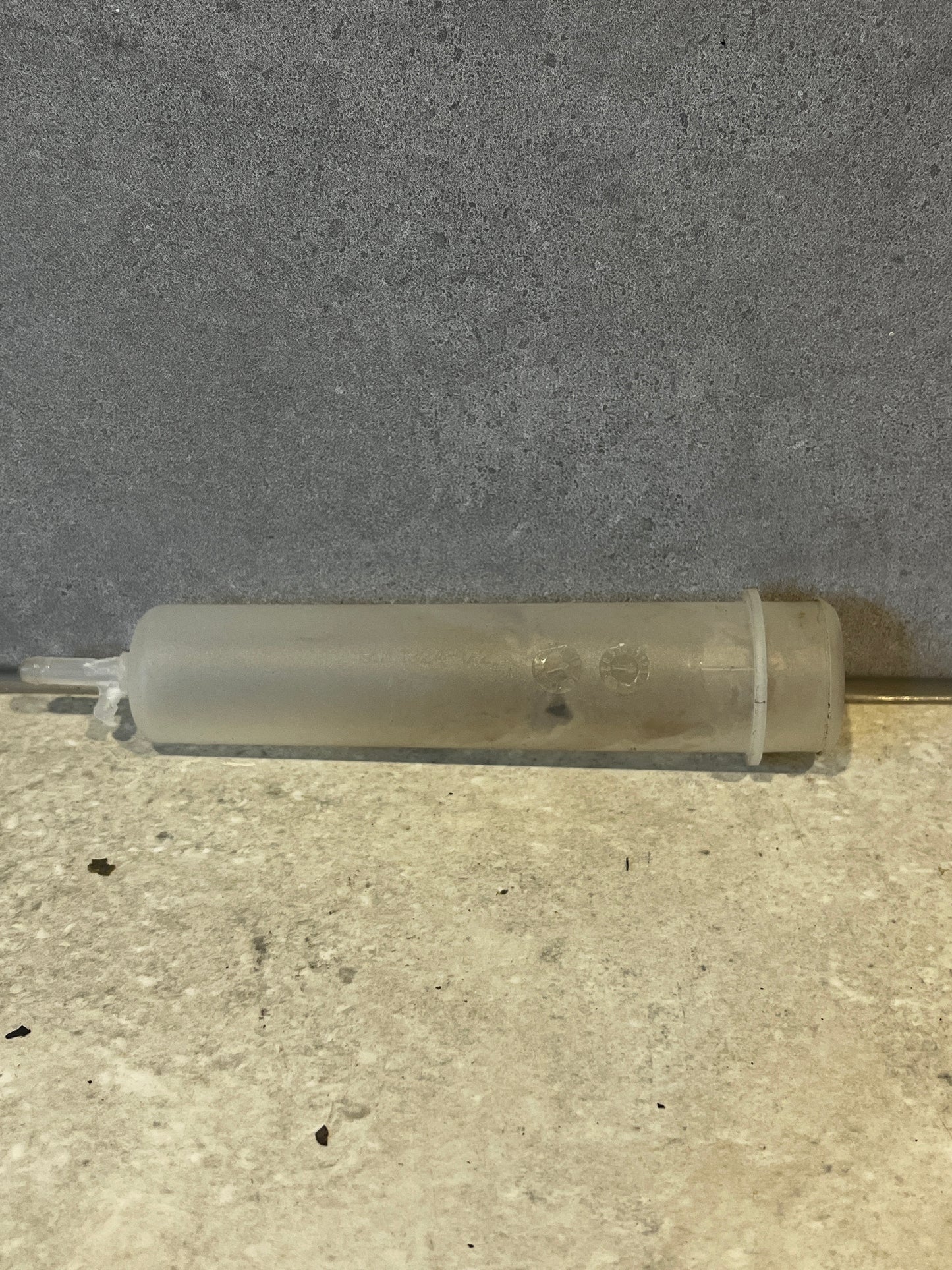 Translucent plastic syringe tube on gray background