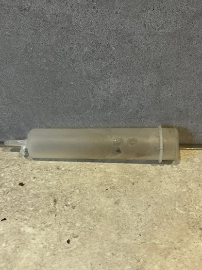 Translucent plastic syringe tube on gray background