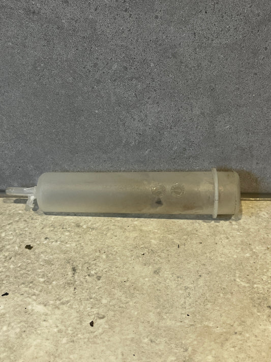 Translucent plastic syringe tube on gray background