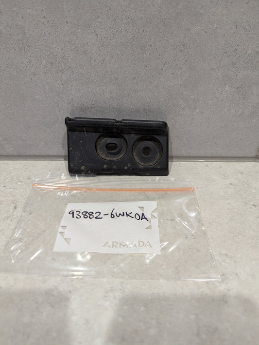 Black plastic automotive cover plate with labeled bag