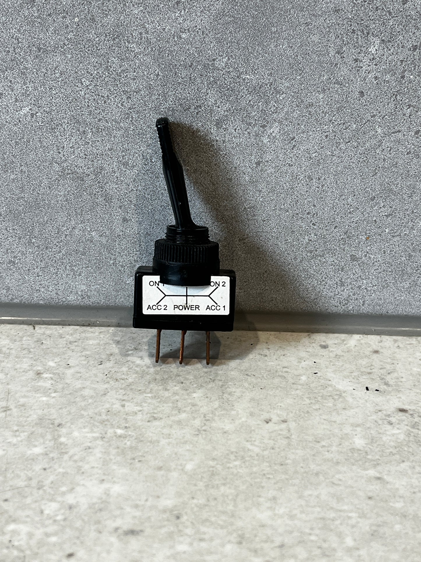 Heavy-duty toggle rotary switch with three copper terminals on a textured surface