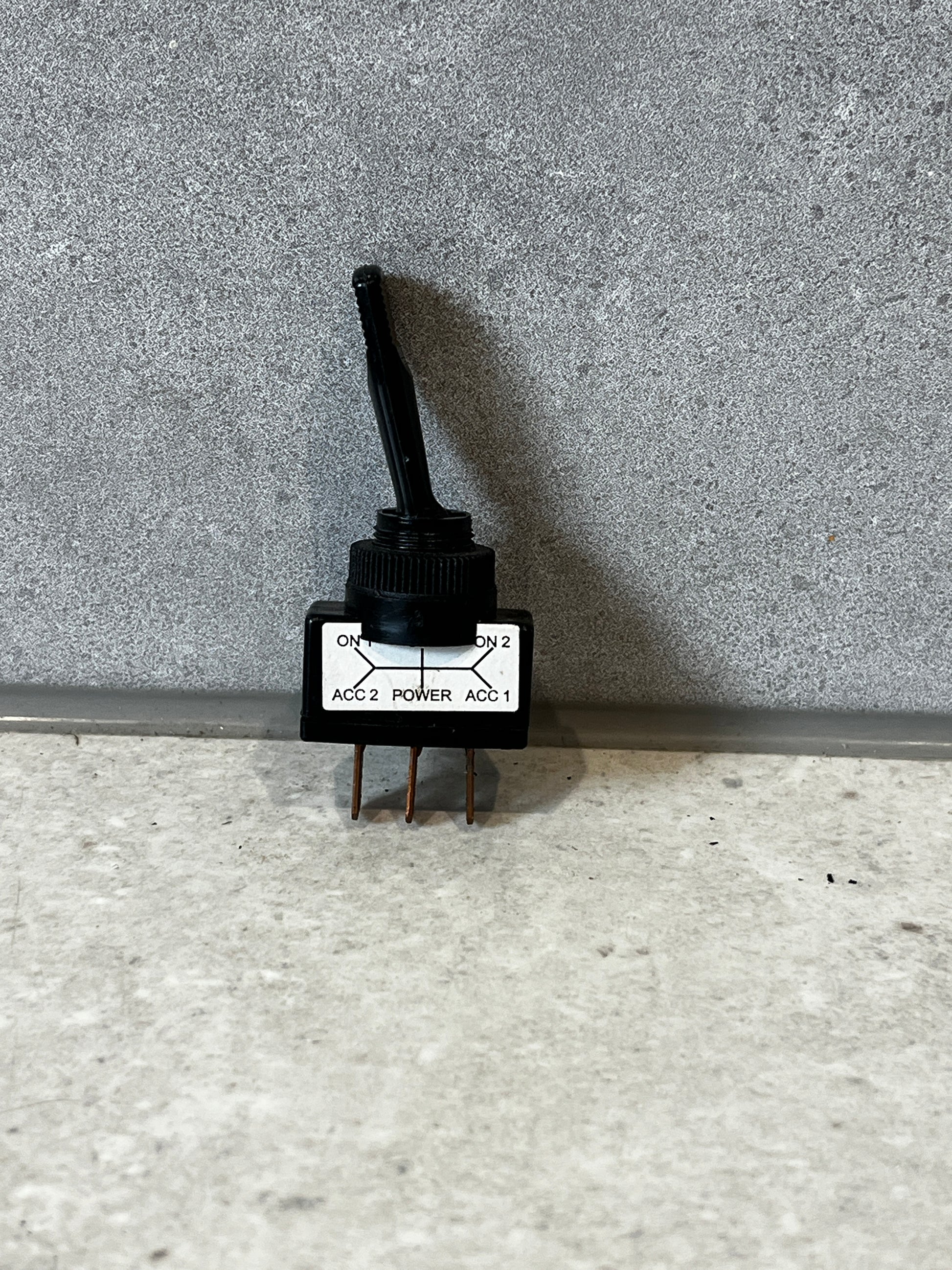 Heavy-duty toggle rotary switch with three copper terminals on a textured surface