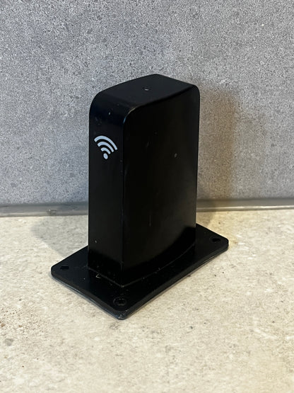 Black Wi-Fi receiver box with wireless signal icon on a countertop