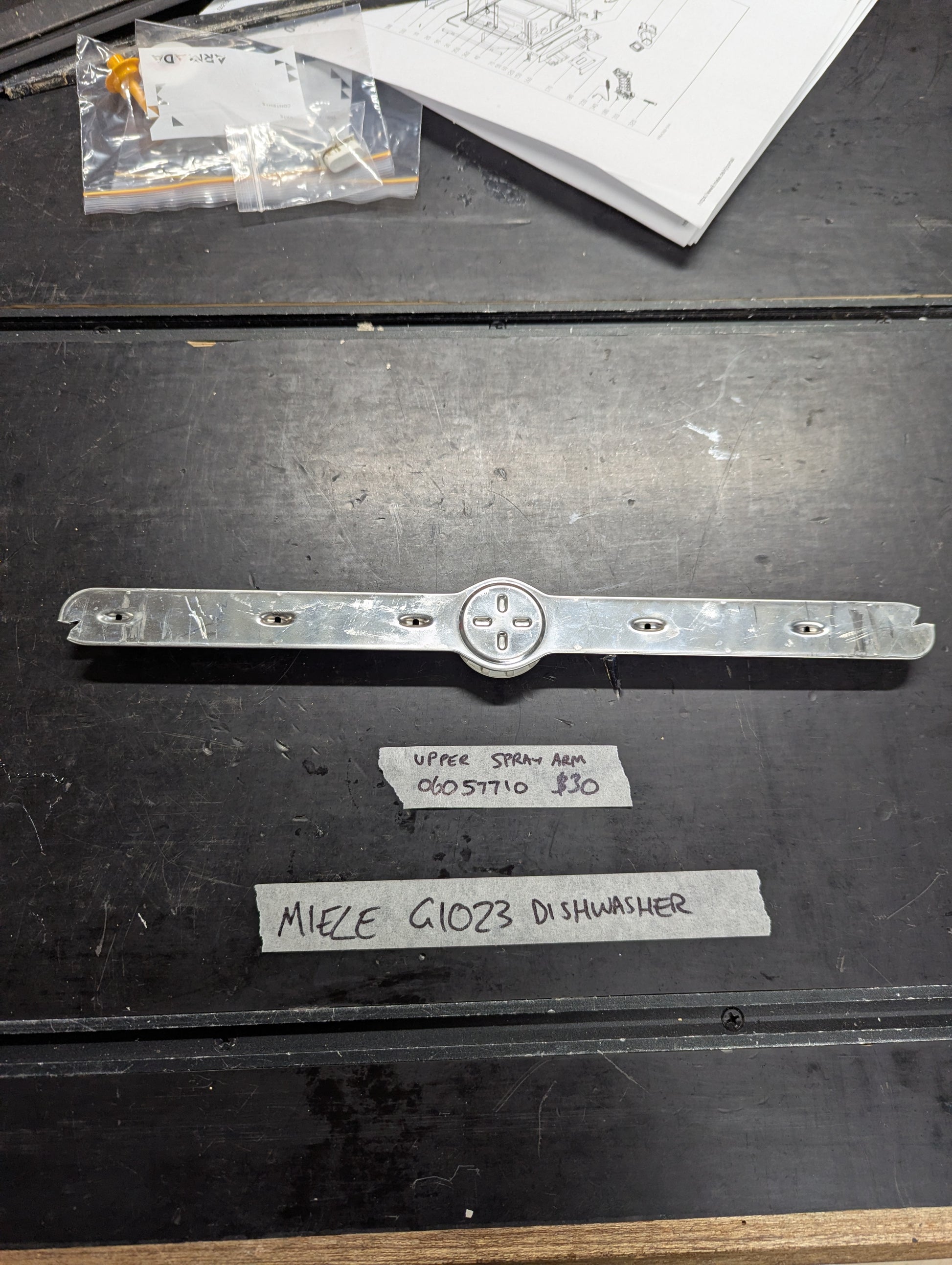 Miele G1023 dishwasher upper spray arm replacement part displayed on table