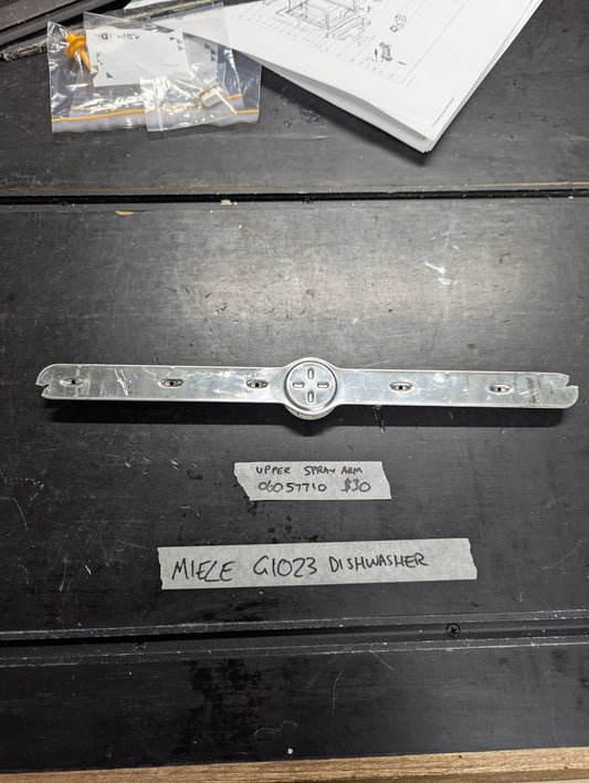 Miele G1023 dishwasher upper spray arm replacement part displayed on table