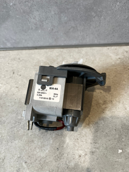 Front and side view of washing machine drain pump motor replacement on a stone surface