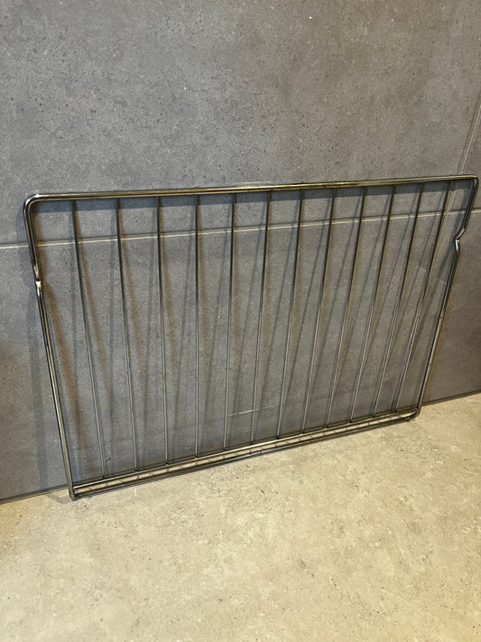 stainless steel oven rack resting against kitchen wall