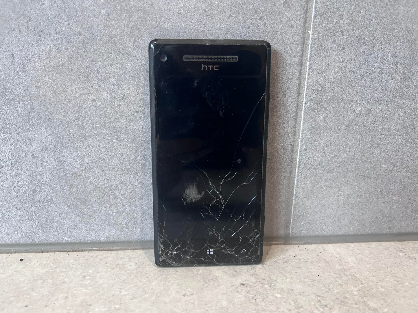 Front view of HTC smartphone with cracked screen